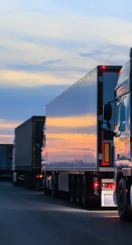 Many Trucks on the Country Road in the Evening at Sunset