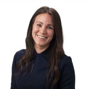 A person is smiling in formal attire against a white background.