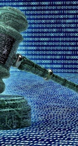 A gavel made of digital code rests on a surface with rows of binary digits in the background.