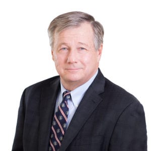 A man in a suit and tie is posing for a professional portrait.