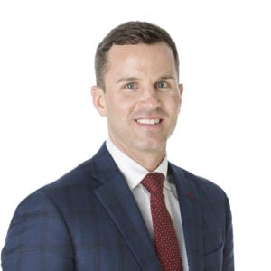 A man in a suit and tie is smiling.